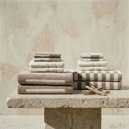 Striped cotton towels set in tan and ecru, folded hand towels and bath sheets.
