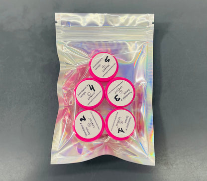Foundation sample set with five circular lids in a pink holographic pouch.