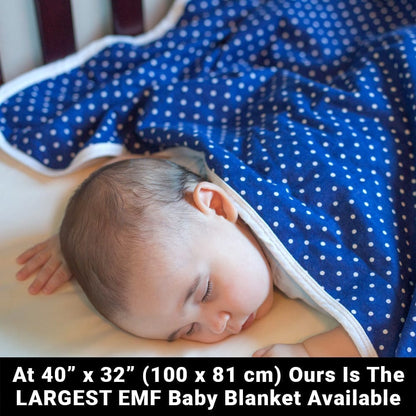 Baby resting under a dark blue baby blanket with white polka dots and white trim