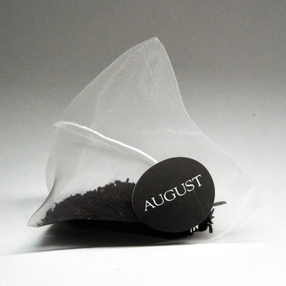 Pyramid tea bag sachet with round August brand seal