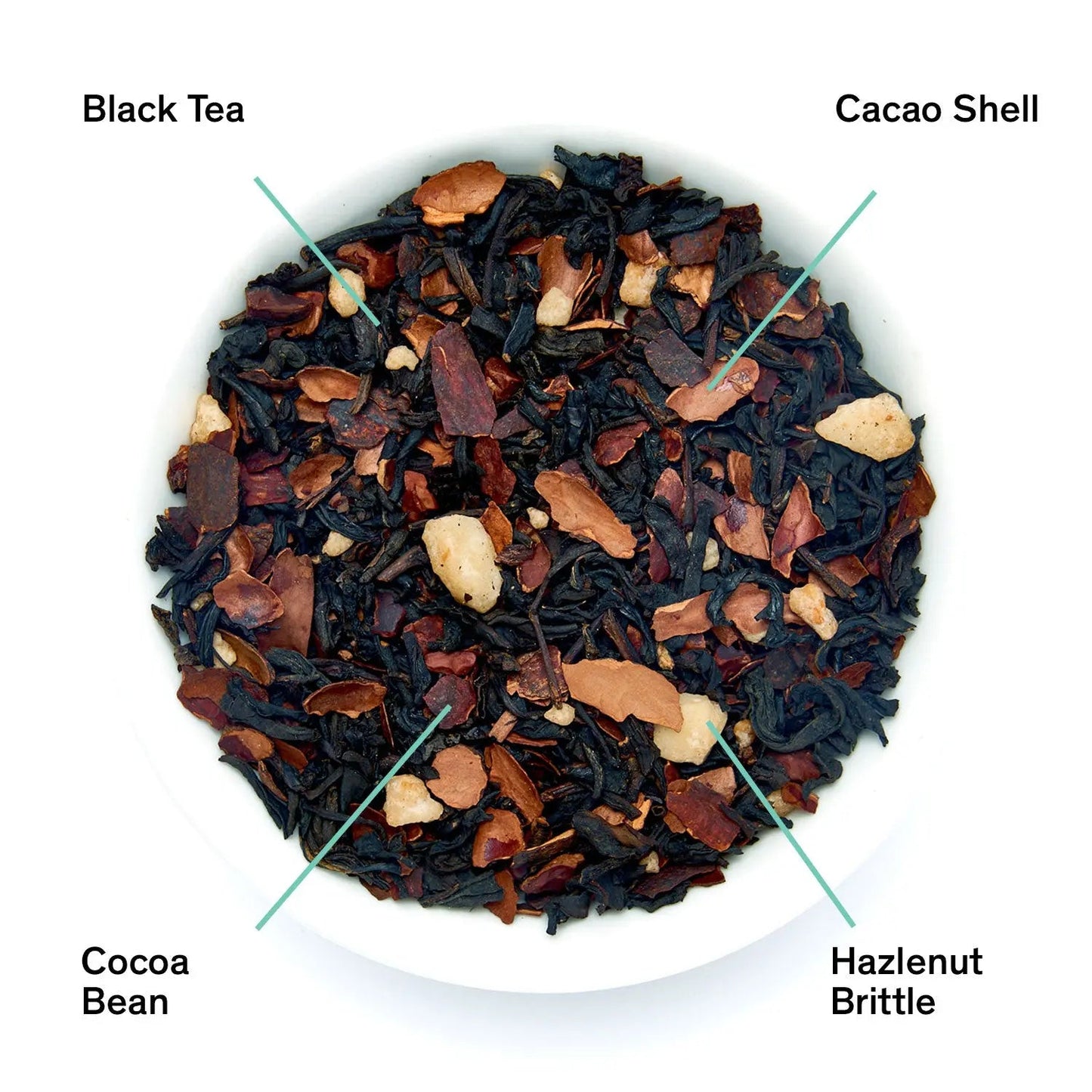 Black tea blend with cacao nibs and hazelnut pieces in a shallow bowl