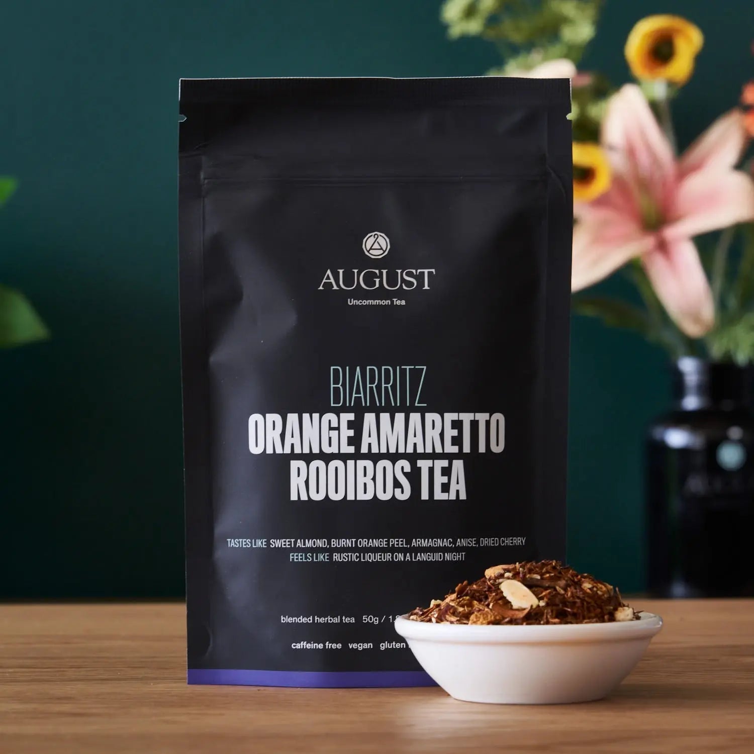 Orange amaretto rooibos tea pouch with bowl of loose tea