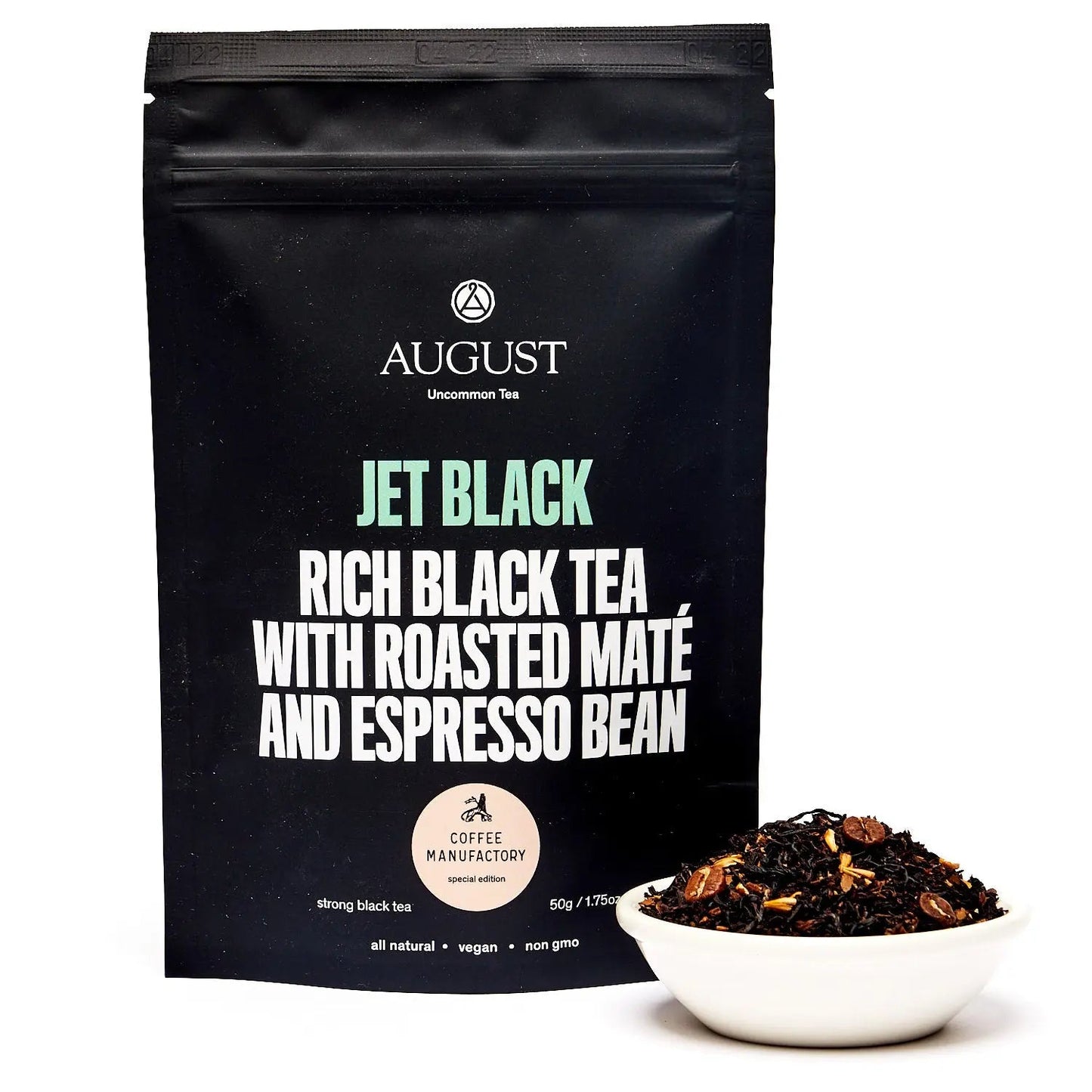 Black tea blend pouch with front label and small bowl of loose tea beside it