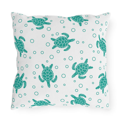Square outdoor cushion pillow with teal sea turtles over a circle ring-dot pattern on white.