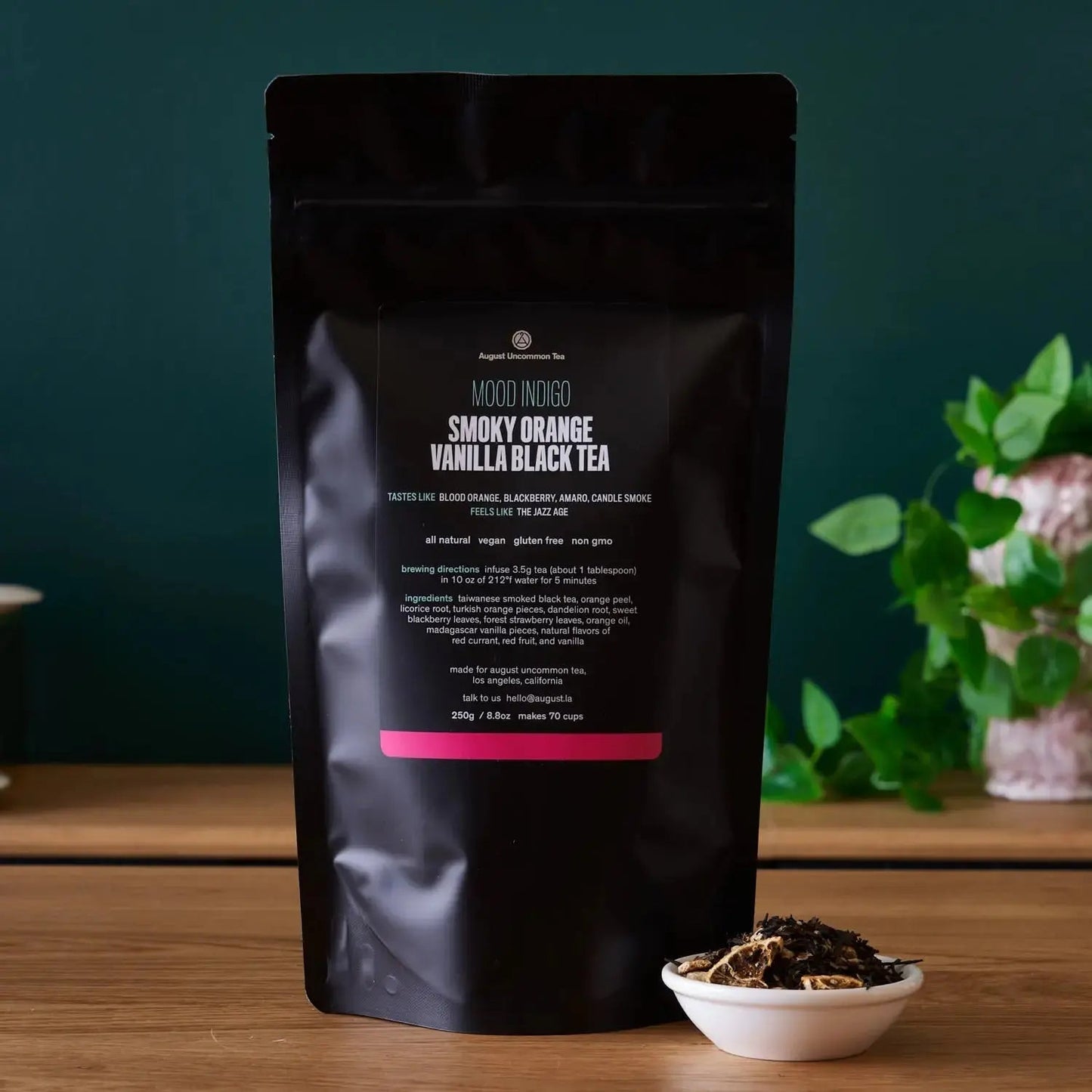 Smoky Orange Vanilla Black tea pouch with loose tea in a small white bowl