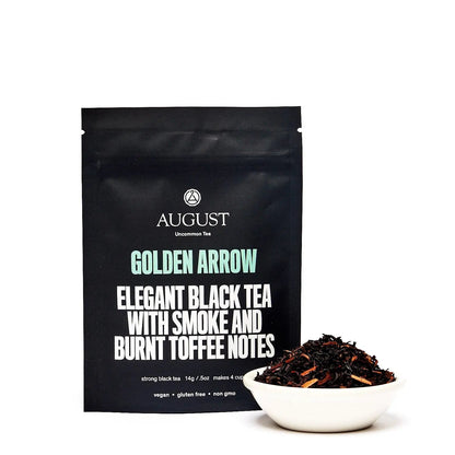 Golden Arrow black tea pouch with bowl of dark tea leaves