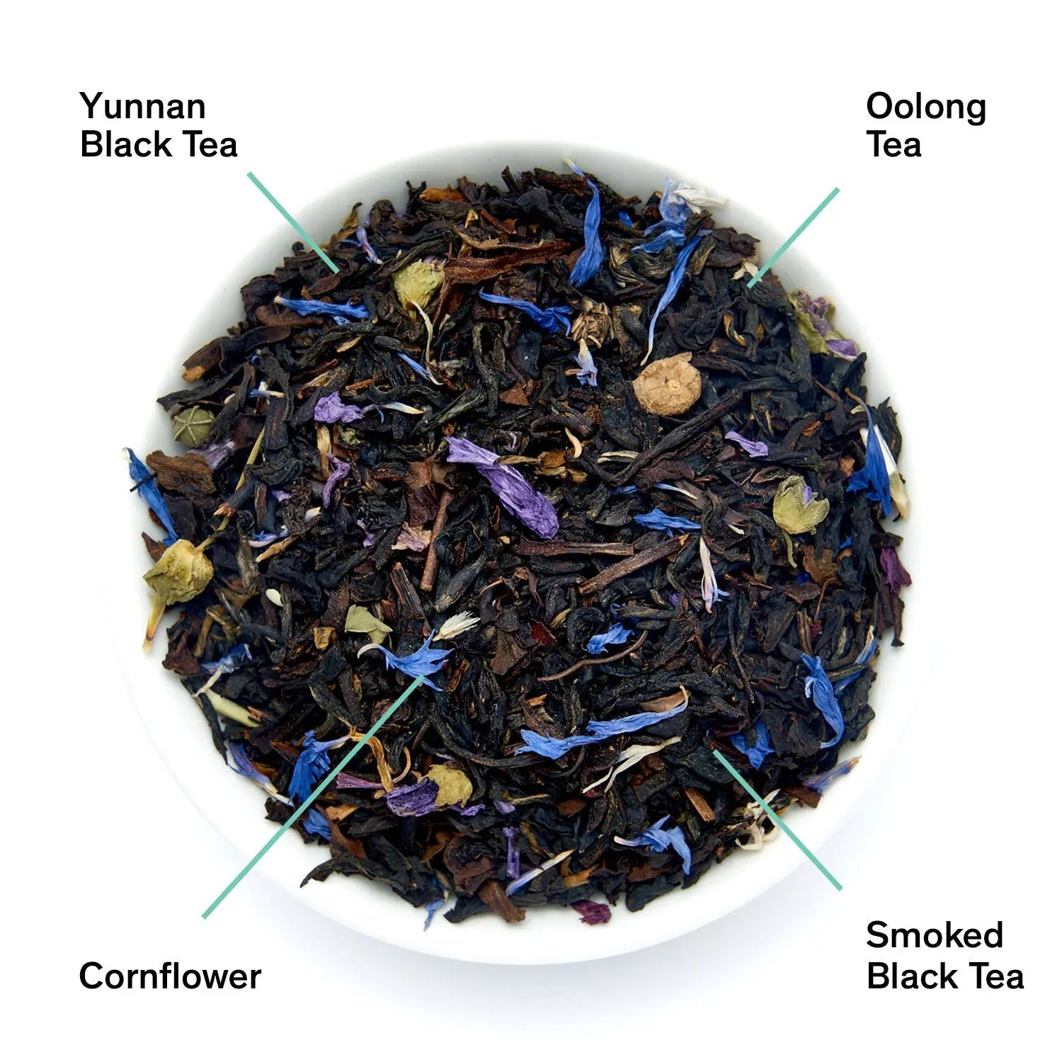 Pile of black tea leaves with blue and purple flower petals in a white dish