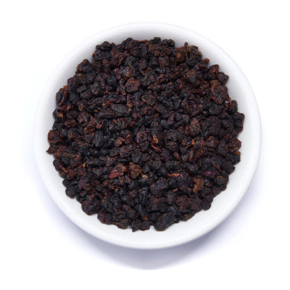 Dark roasted oolong tea leaves in white bowl