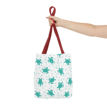 Tote bag with repeating teal sea turtle pattern and red carrying handles