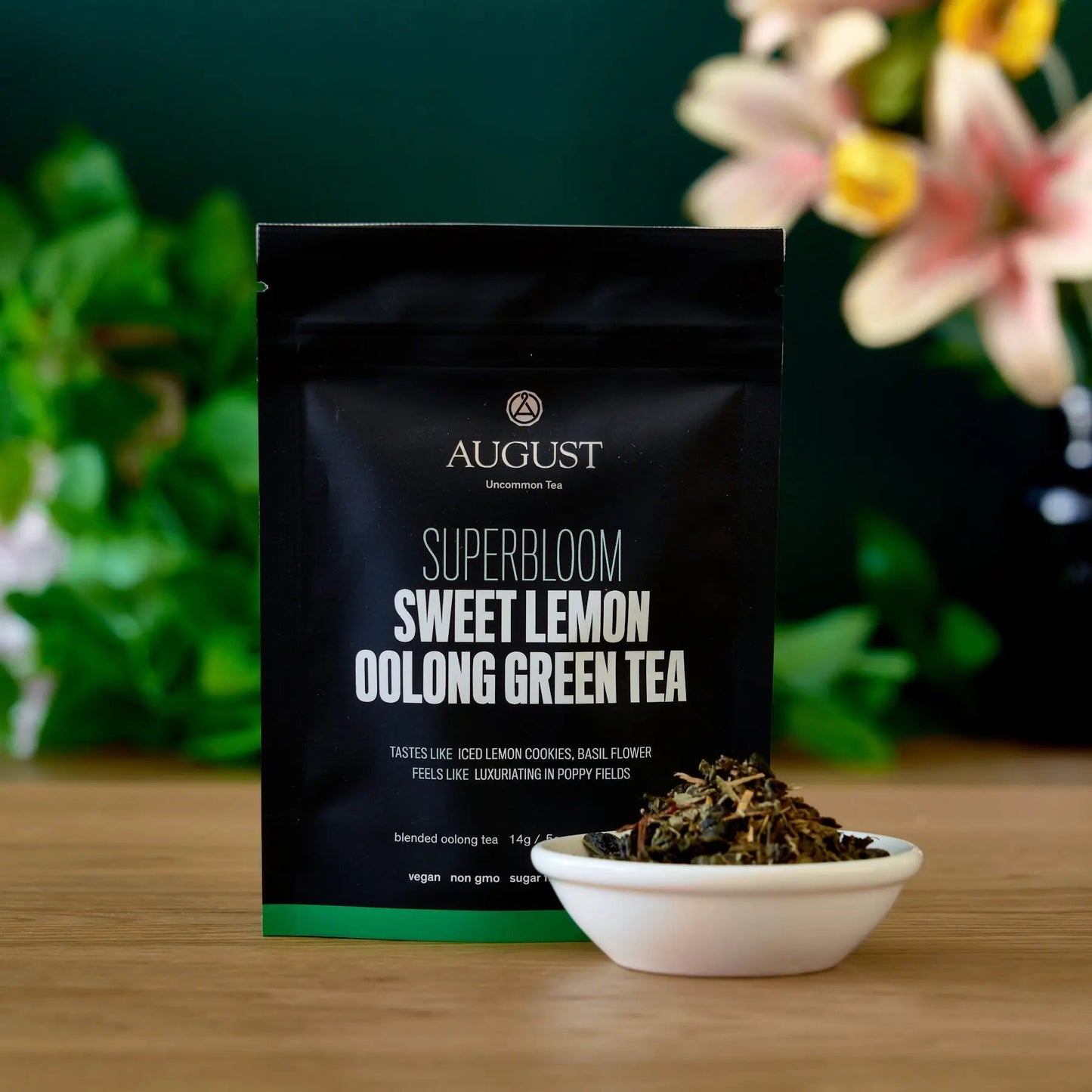 Sweet Lemon Oolong Green Tea pouch with a bowl of loose tea leaves.