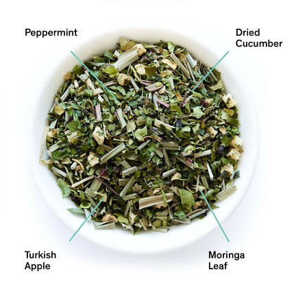 White bowl of dried herbal tea leaves labeled peppermint, dried cucumber, moringa leaf