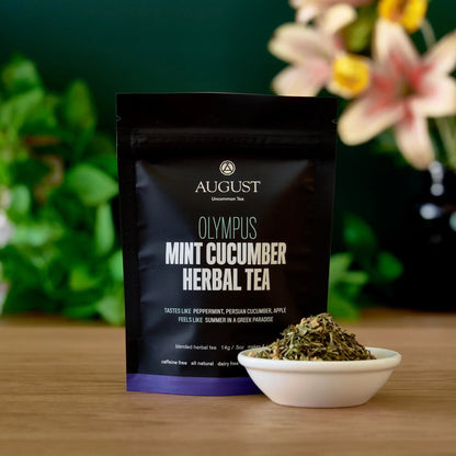 Black herbal tea pouch with mint cucumber herbal tea label and bowl of dried tea leaves