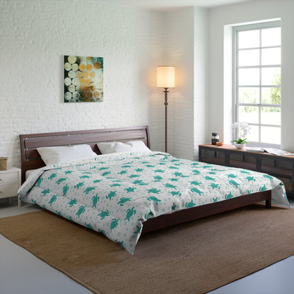 Comforter with teal all-over flower pattern on white, neatly laid on bed