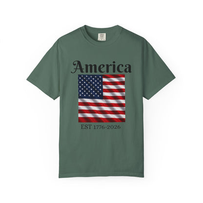 Forest green T-shirt with “America” over US flag and “EST 1776-2026” graphic on front