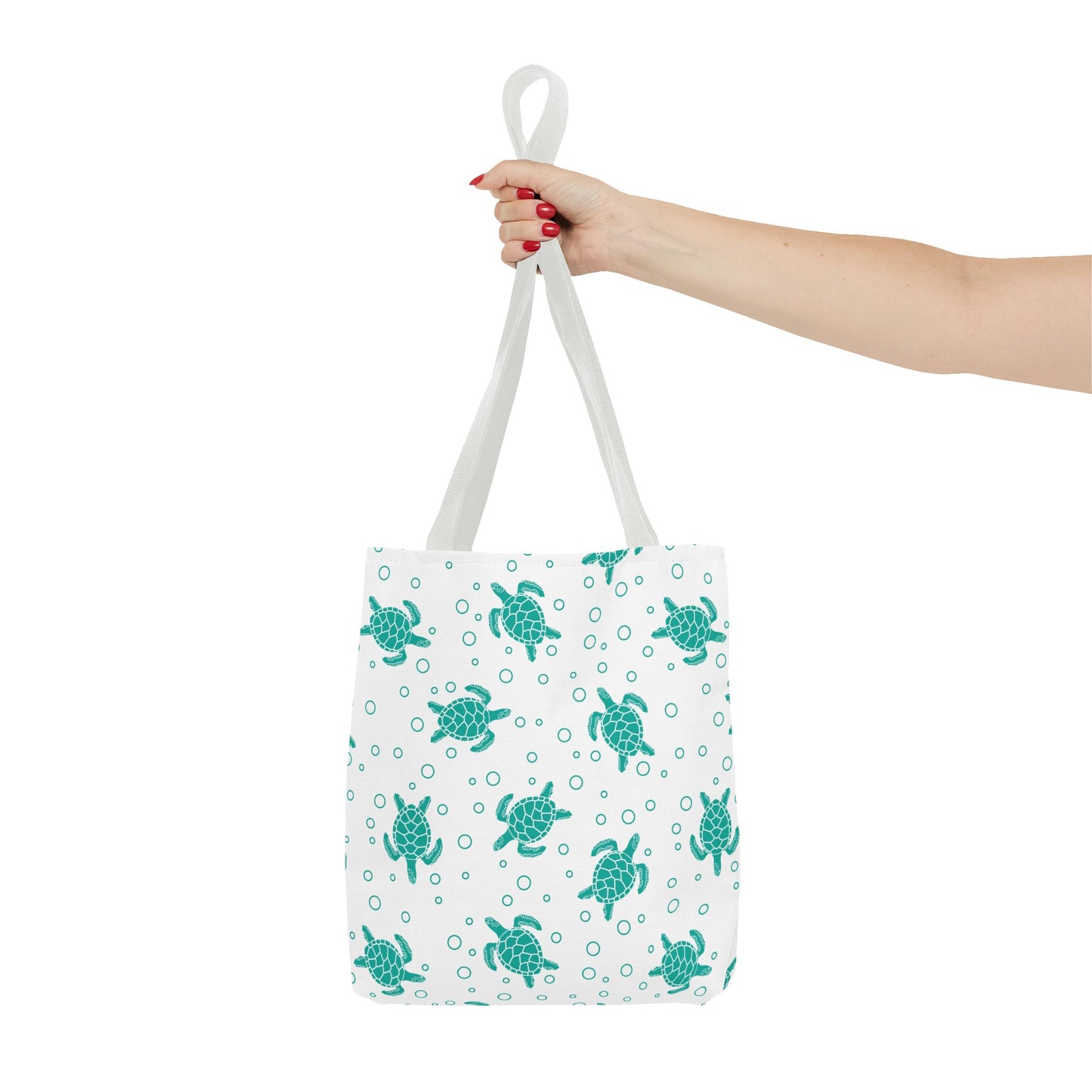 Tote bag with repeating teal sea turtle pattern and white carrying handles, held up