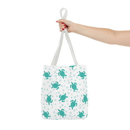 Tote bag with repeating teal sea turtle pattern and white carrying handles, held up