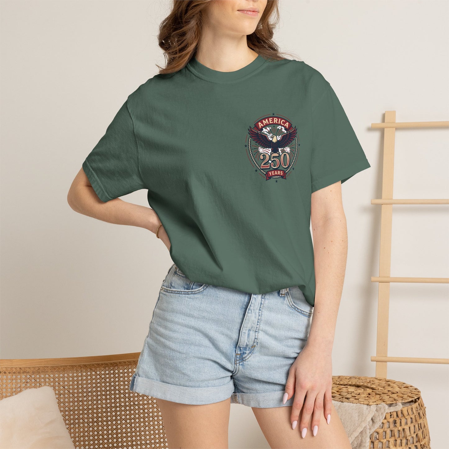 Green T-shirt worn by model, with round “America 250 Years” emblem on chest