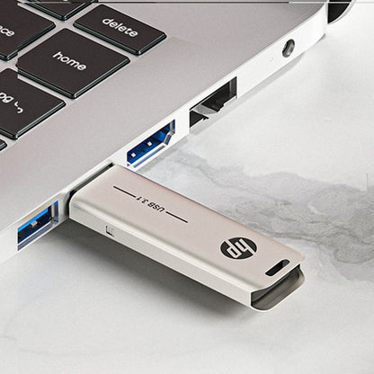 HP USB flash drive inserted into a USB port, metallic silver body with HP logo