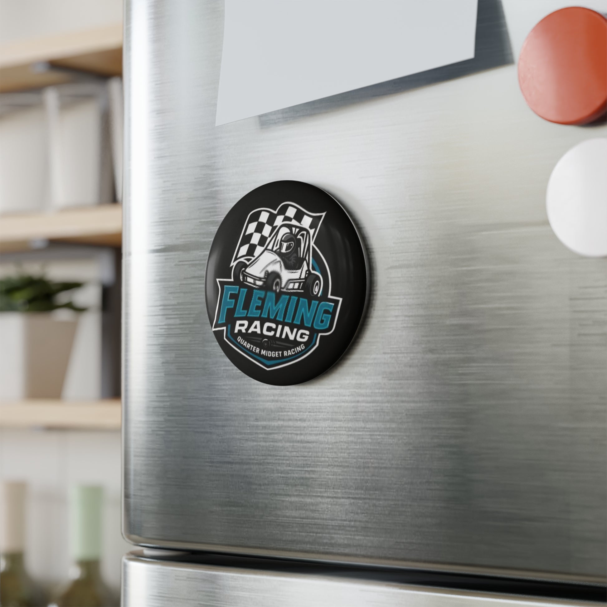 Round black Fleming Racing logo magnet on brushed metal fridge surface