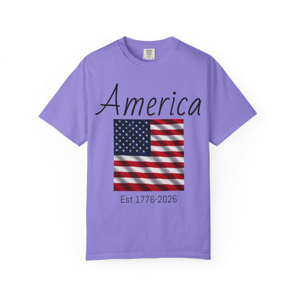 Lavender unisex t-shirt with “America” script, U.S. flag, and “Est 1776-2026”