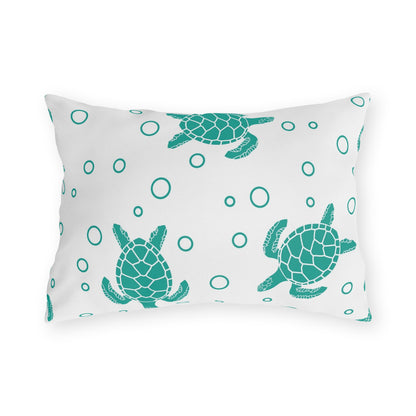 Outdoor cushion pillow with teal sea turtle and circle ring-dot pattern on white fabric.
