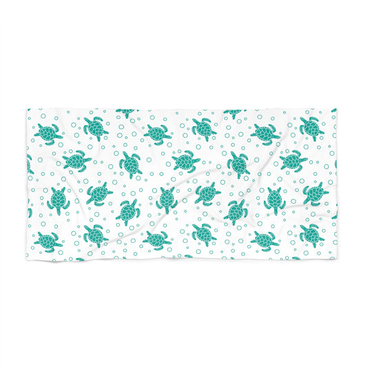 Beach towel with teal sea turtle pattern on white, rectangular folded layout