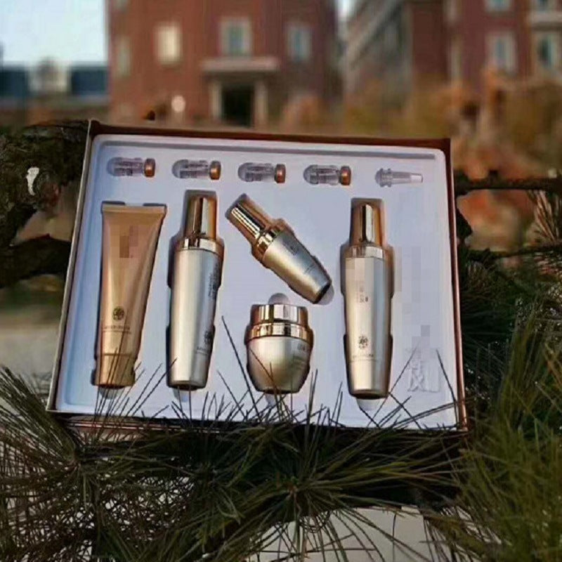 Moisturizing skincare set in open box with gold-capped bottles and cream tube