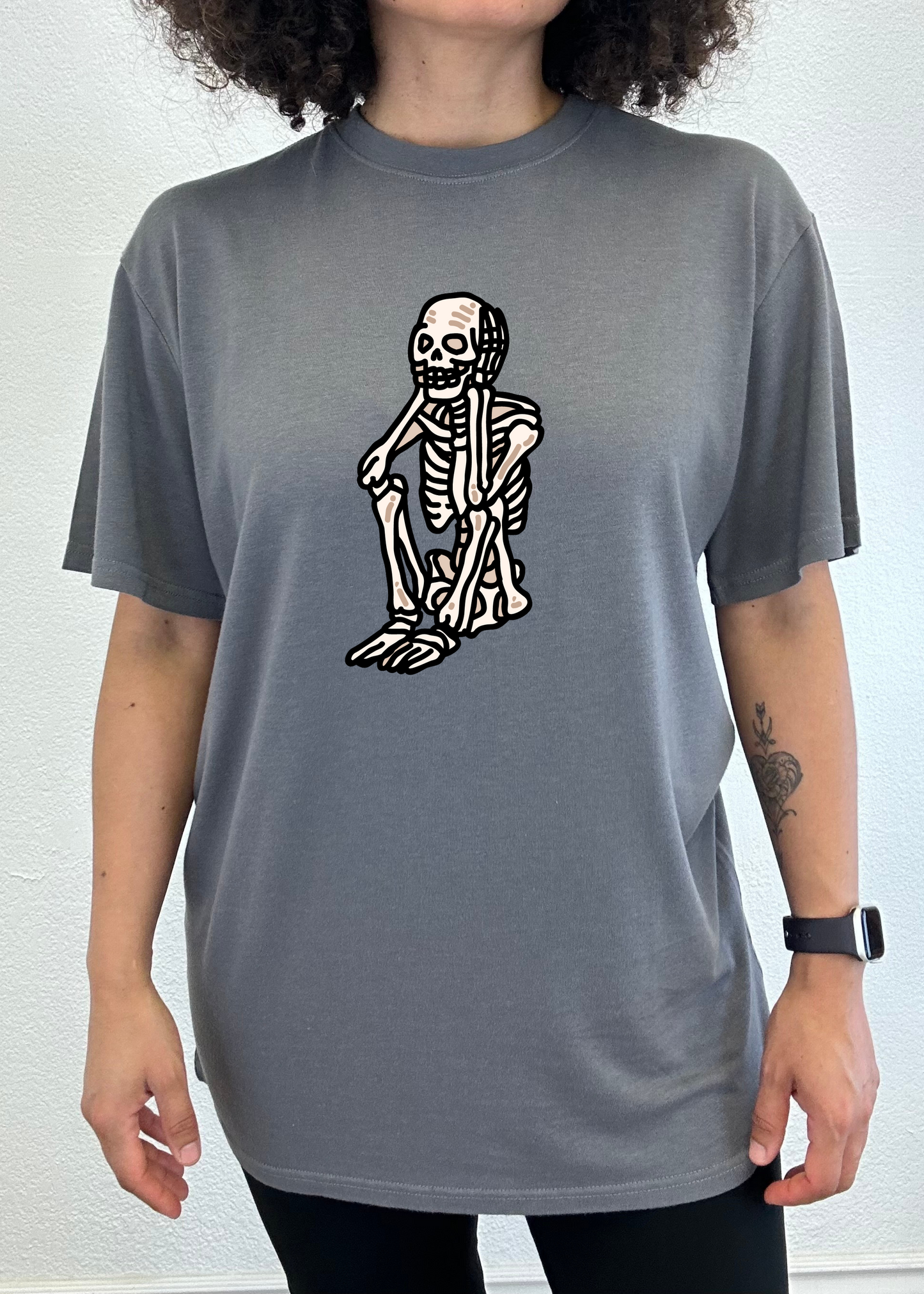 Slate gray unisex graphic T-shirt with white skeleton standing print on chest.