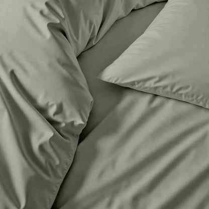 Sateen sheet set fabric in sage green, close-up of bed linens and pillow edge