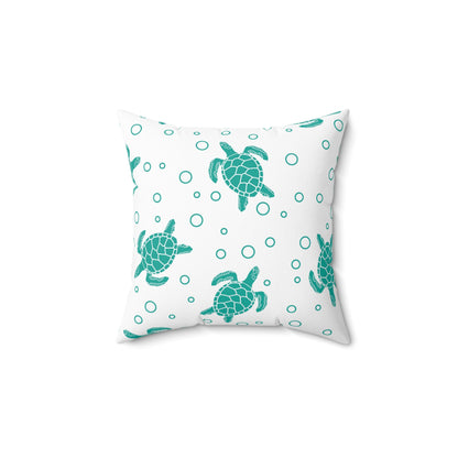 Square decorative pillow with teal sea turtle print and teal circle accents on white fabric