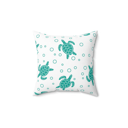 Square decorative pillow with teal sea turtle print and small teal circle accents on white fabric