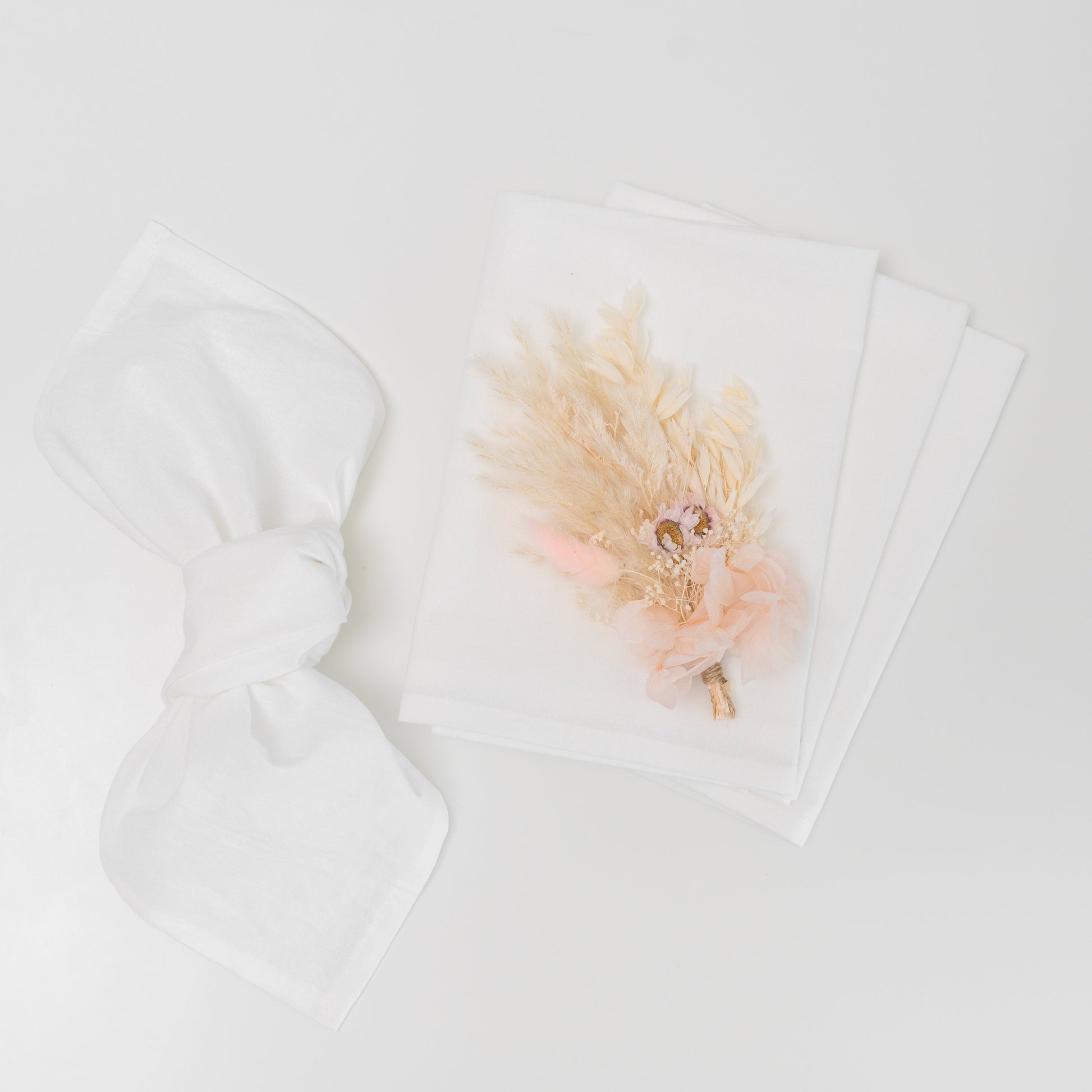 Flour sack napkins, white, with a dried-flower accent on one napkin
