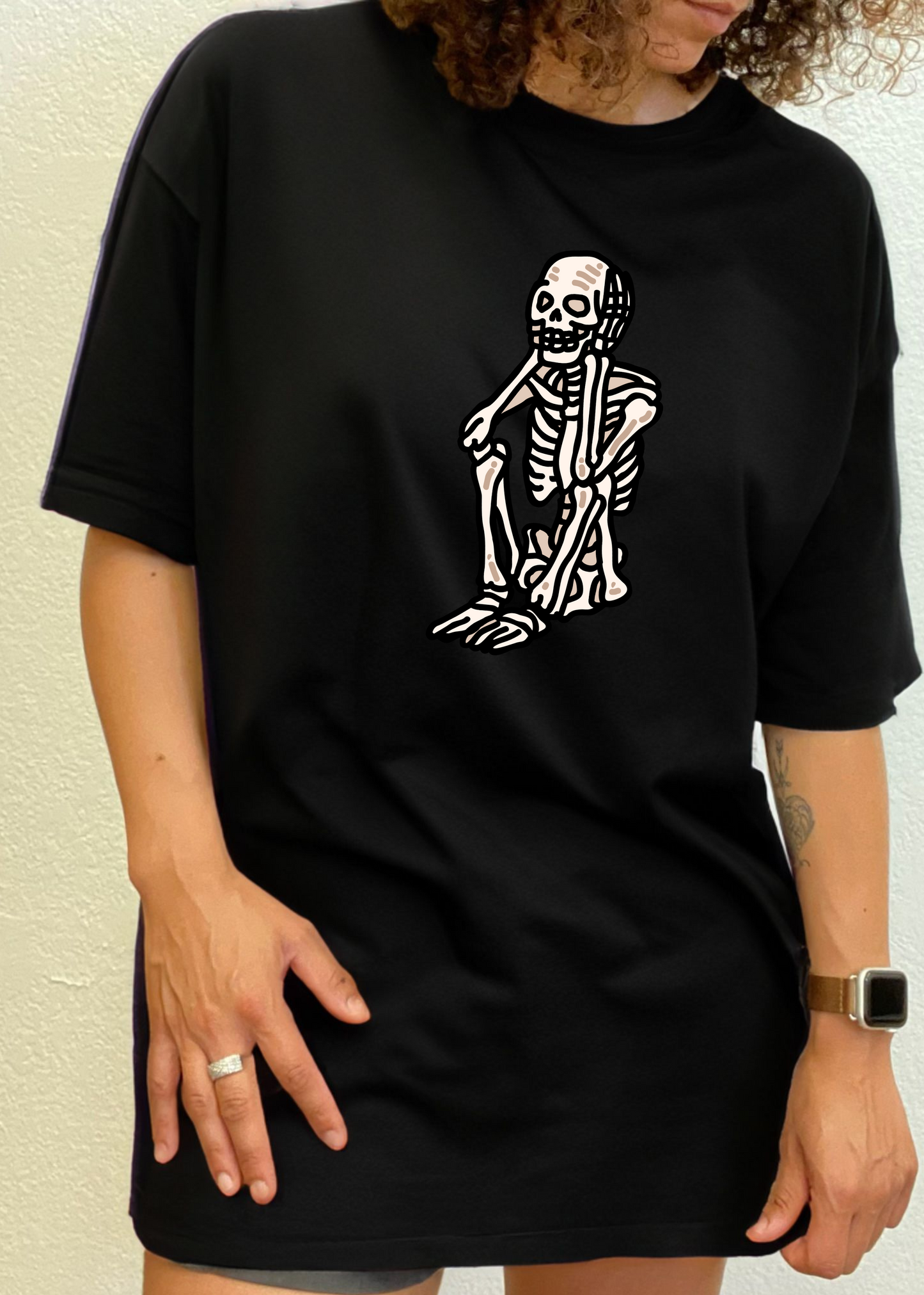 Black unisex graphic T-shirt with white skeleton standing print on chest.