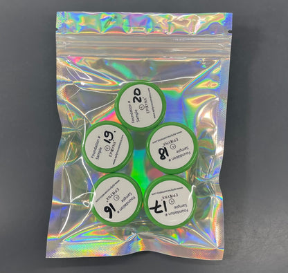 Foundation sample set with five circular lids in a green holographic pouch.