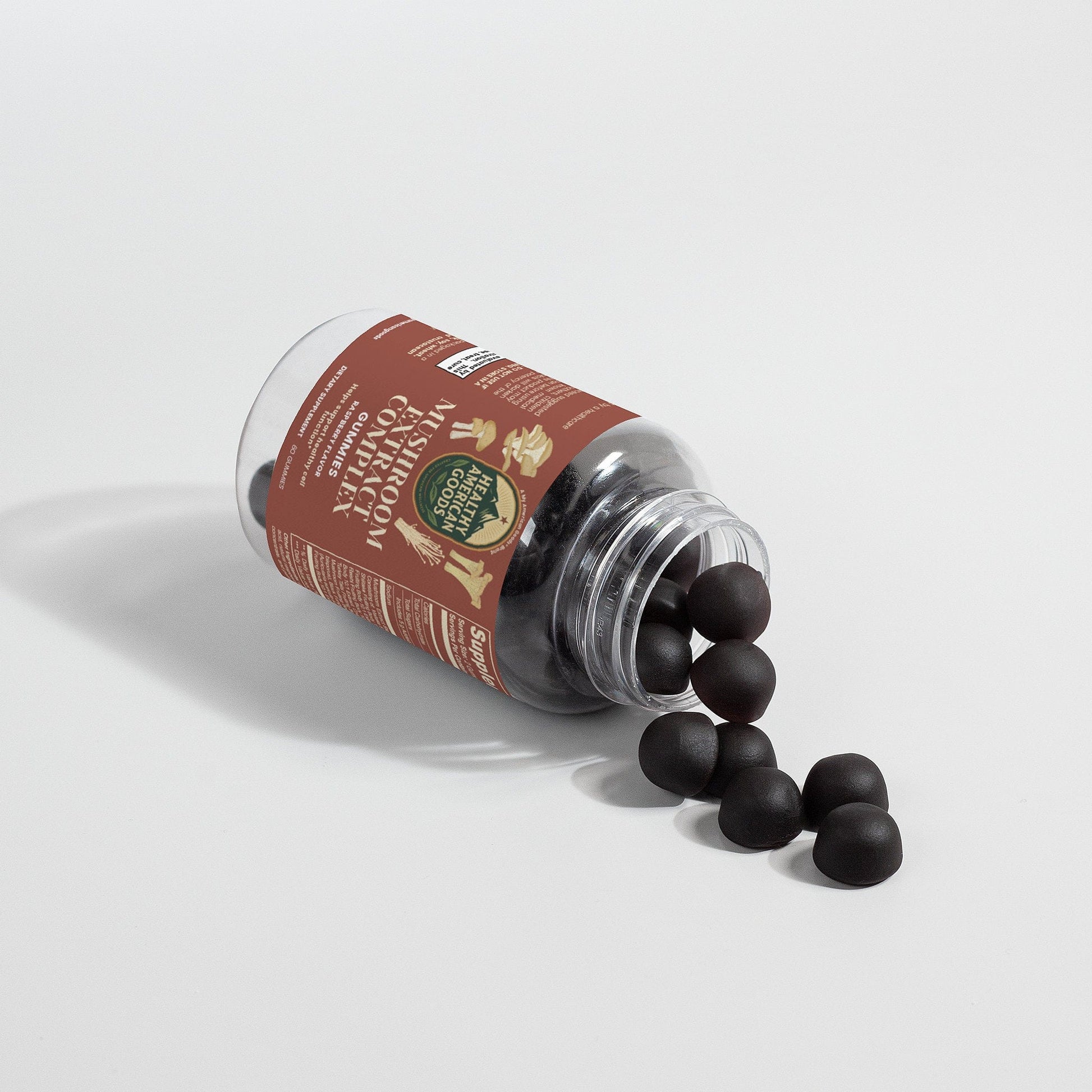 Mushroom extract complex gummies bottle tipped with dark gummy pieces spilling