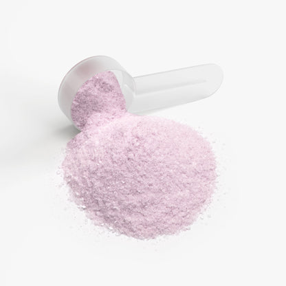 Powder scoop holding light pink supplement powder
