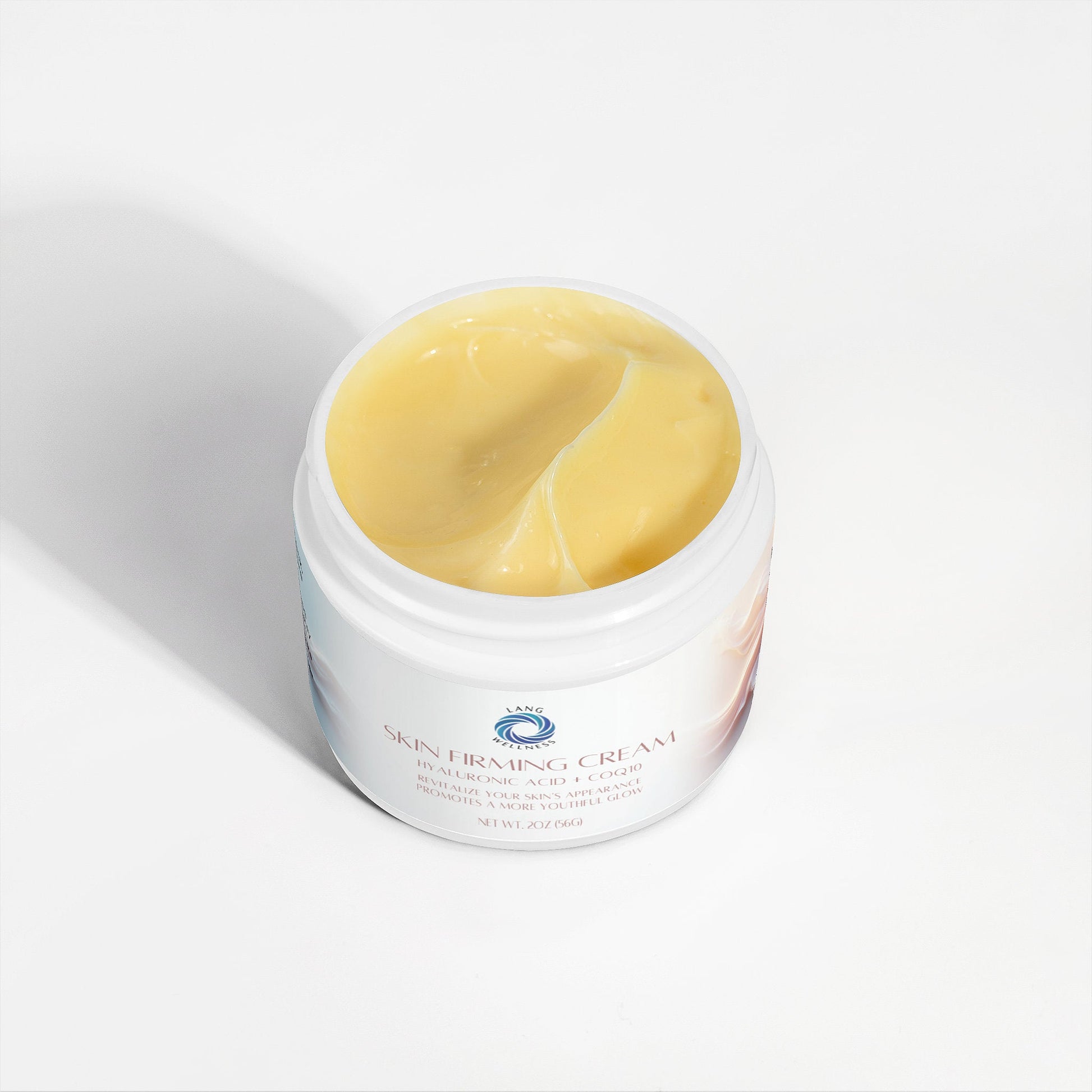 Skin firming cream jar open, showing smooth yellow cream inside