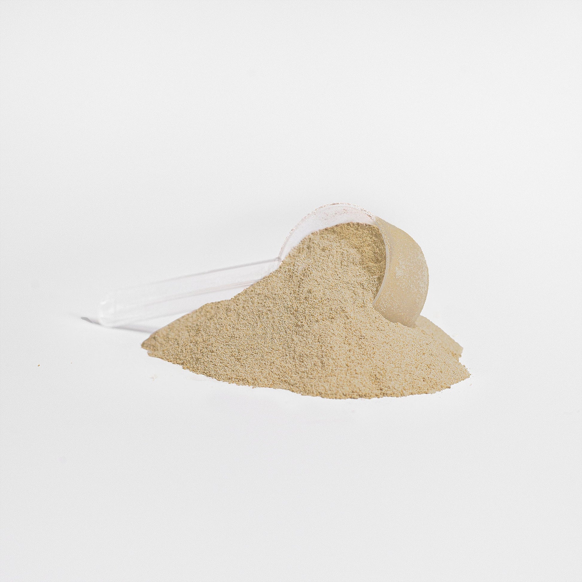 Tan whey protein powder shaped like a heart with a light powder trail