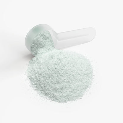 Jar with pale mint cap and spoonful of fine light-gray powder