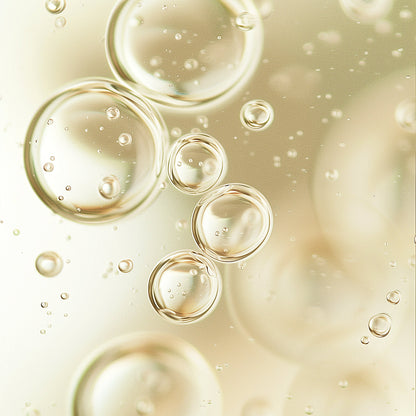 Close-up of pale oil droplets and bubbles in gel-like liquid