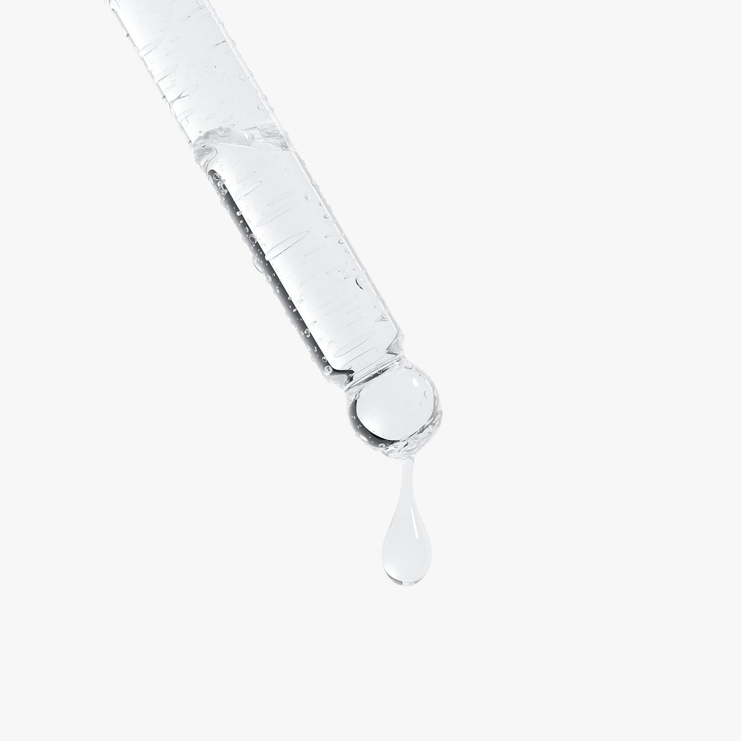 Glass dropper with clear serum liquid, single drop falling