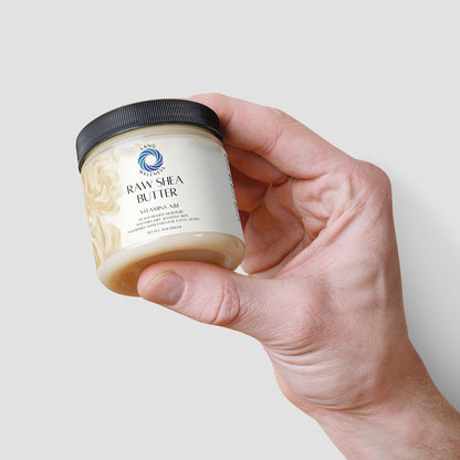 Two hands holding a shea butter jar with black lid, label partially visible