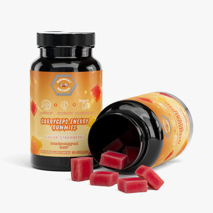 Energy gummy supplement bottle tilted with red strawberry gummies scattered