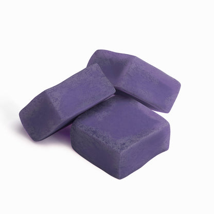 Purple square gummy pieces, stacked in a loose pile.