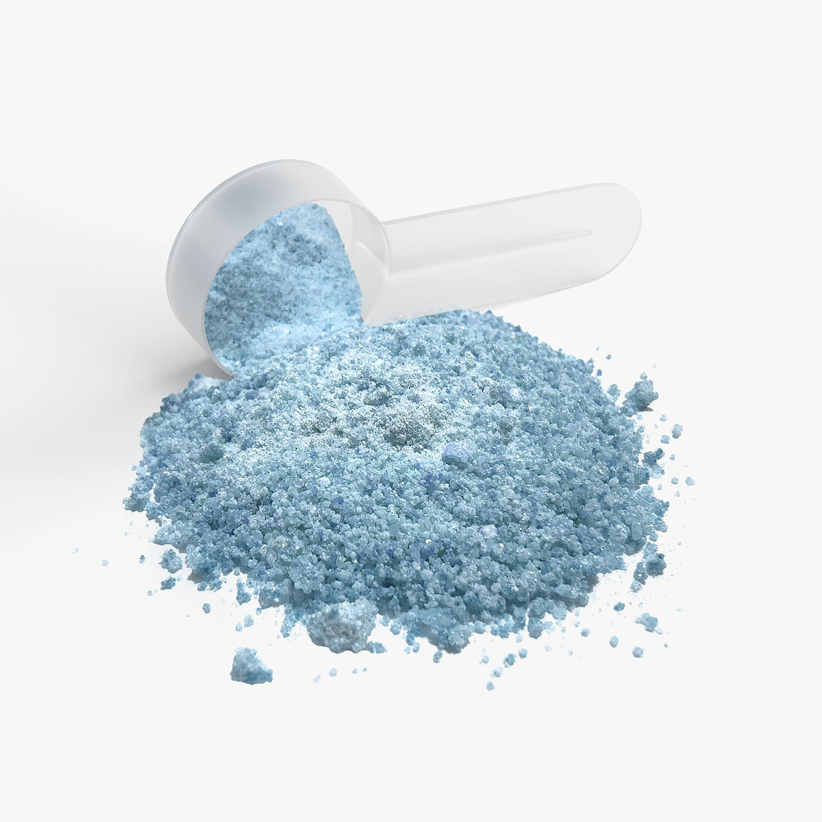 Blue supplement powder pouring from a scoop; mound of fine powder