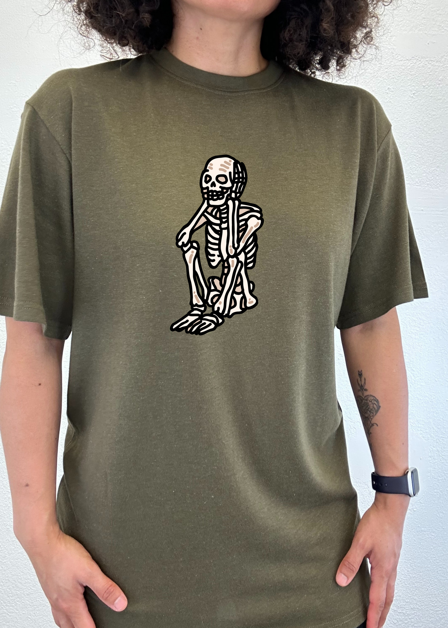Olive green unisex graphic T-shirt with white skeleton standing print on chest.