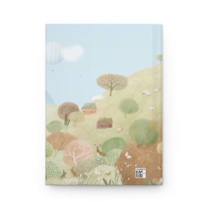 Hardcover journal with countryside hillside illustration—trees, houses, and rolling fields
