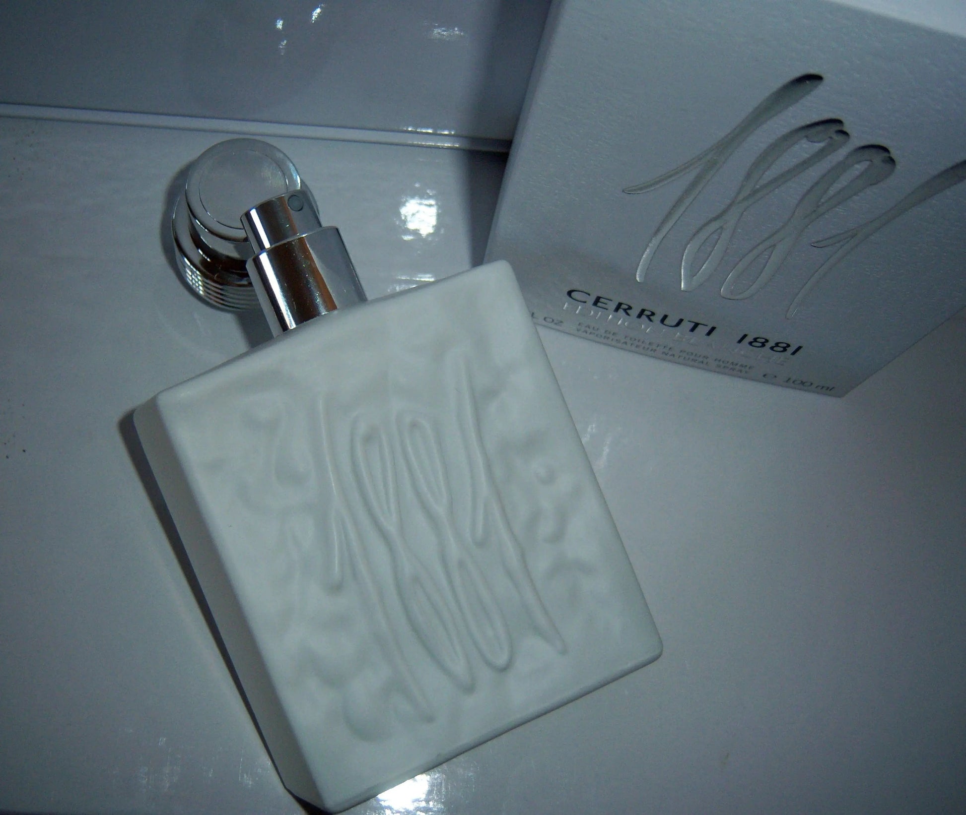 Clear eau de toilette bottle with chrome pump and matching box