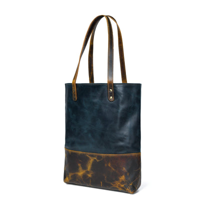 Dark blue leather tote with tan-brown bottom panel and twin top handles