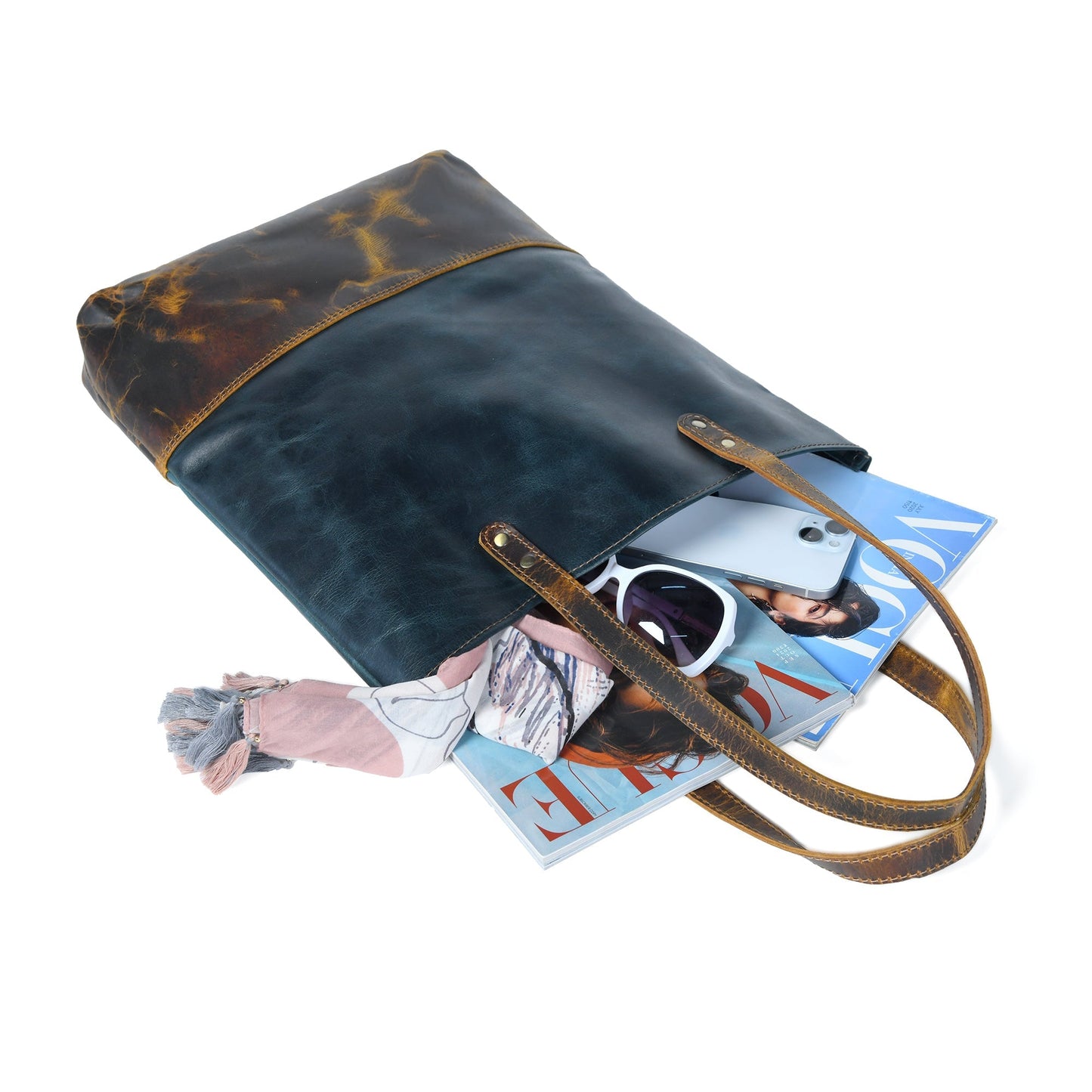 Dark blue leather tote with tan-brown trim, open top with items inside